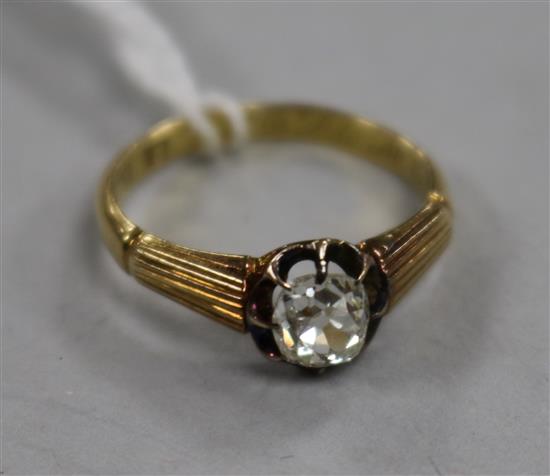 A 20th century 18ct gold and claw set solitaire diamond ring with reeded shoulders, size K.